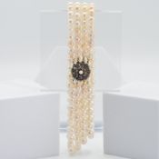 An impressive antique four row cultured pearl choker necklace strung to a circular clasp set with