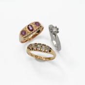 An 18ct yellow gold 'gypsy' style ring set with three oval cut garnets, 2.82gm, size O 1/2, a