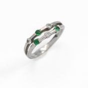 An 18ct white gold double row ring set with three round cut emeralds & three round brilliant cut