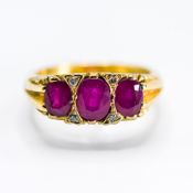 An 18ct yellow gold scroll design ring set with three oval cut rubies, total ruby weight approx. 1.