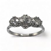 An impressive platinum three stone ring set with three older round cut diamonds, total diamond