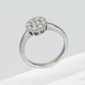 An 18ct white gold flower style cluster ring set centrally with two baguette cut diamonds, total