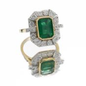 An impressive 18ct yellow & white gold ring set centrally with an emerald cut emerald, approx. 3.