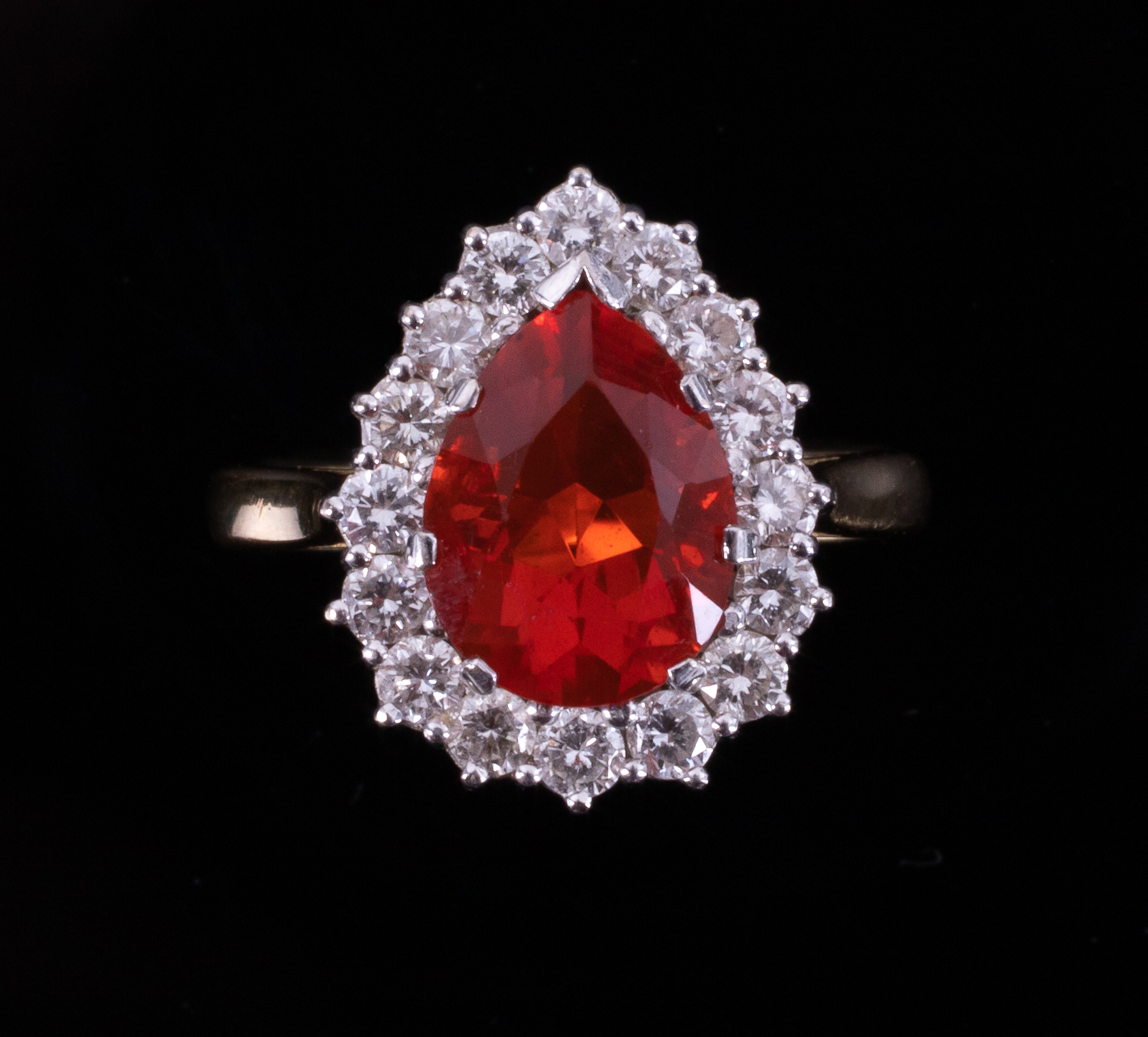 An 18ct yellow & white gold pear shaped cluster ring set with a central pear shaped fire opal