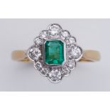 An 18ct yellow & white gold cluster style ring set with a central emerald cut emerald