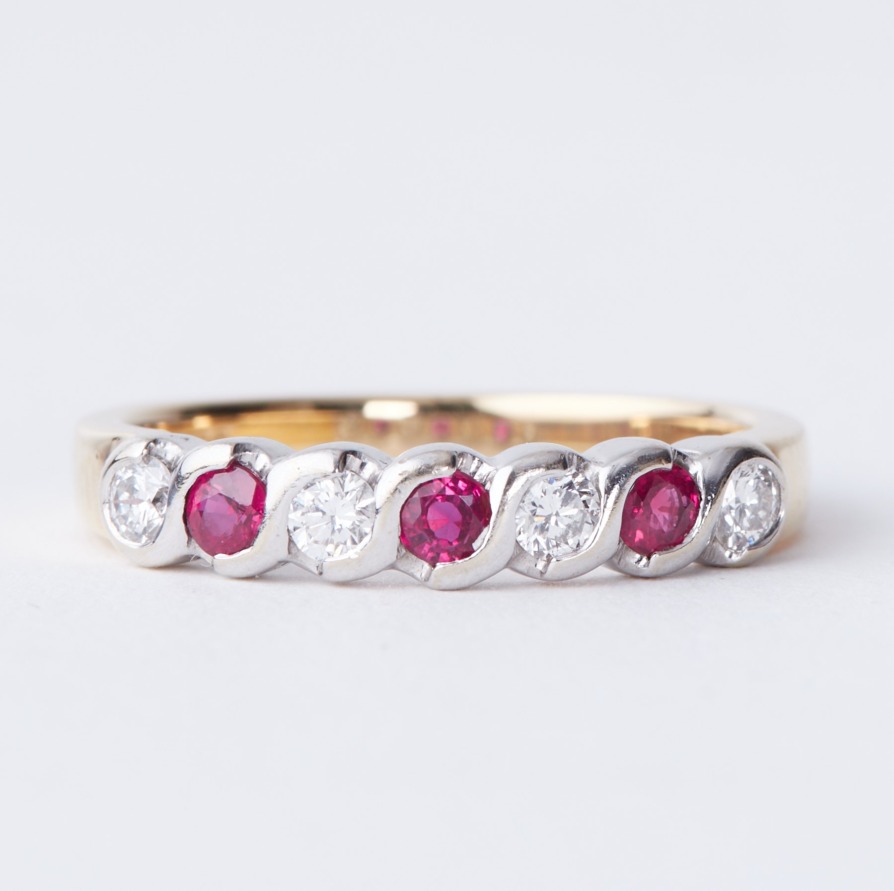 An 18ct yellow & white gold half eternity style ring set with diamonds and rubies