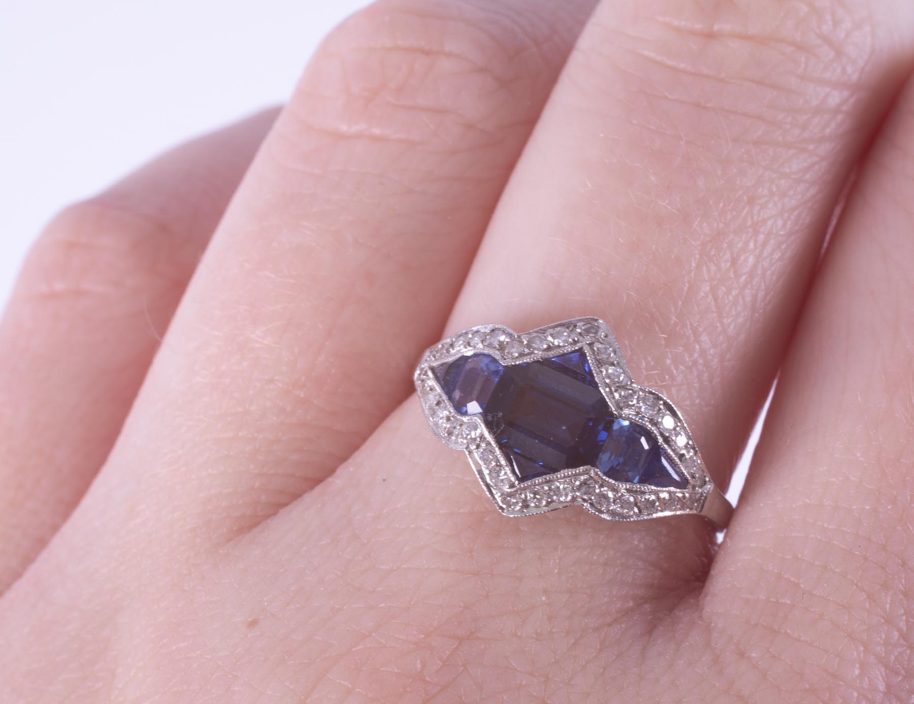 A platinum Art Deco ring (no hallmarks) set with a central emerald cut sapphire - Image 2 of 2