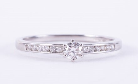 A platinum ring set with a central round brilliant cut diamond, approx. 0.15 carats