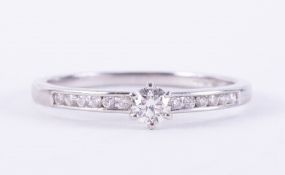 A platinum ring set with a central round brilliant cut diamond, approx. 0.15 carats