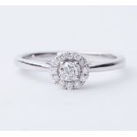 An 18ct white gold halo style ring set with round brilliant cut diamonds