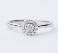 An 18ct white gold halo style ring set with round brilliant cut diamonds