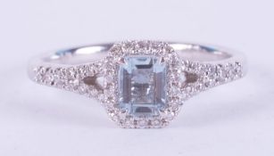 An 18ct white gold ring set with a central emerald cut aquamarine, approx. 0.50 carats