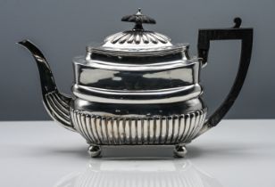 George III silver teapot, cushion shape with half fluted body, black carved finial, bun feet,