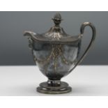 A George III ornate silver cream jug with shaped lid (loose) decorated with ribbon and Follette