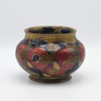 A William Moorcroft vase decorated with Pomegranate on an ochre ground also decorated inside,