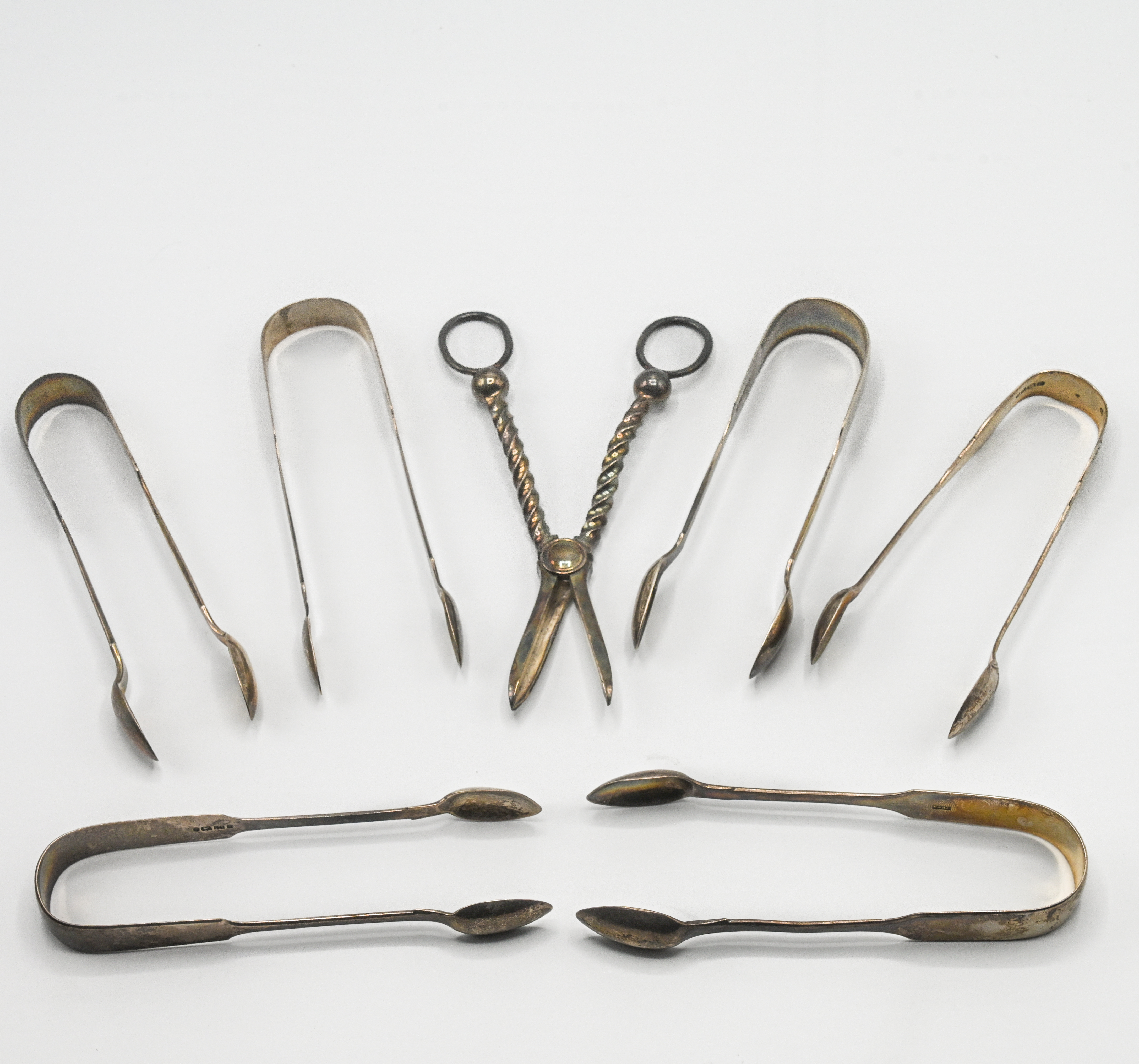 A selection of silver tongs & a pair of silver grape scissors, Exeter, total weight 10.60oz.