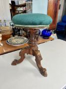 A Victorian carved walnut revolving piano stool.