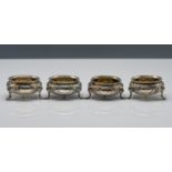 Set of four Victorian silver salts pots, floral pattern, 3 feet, beaded edge with blank cartouche,