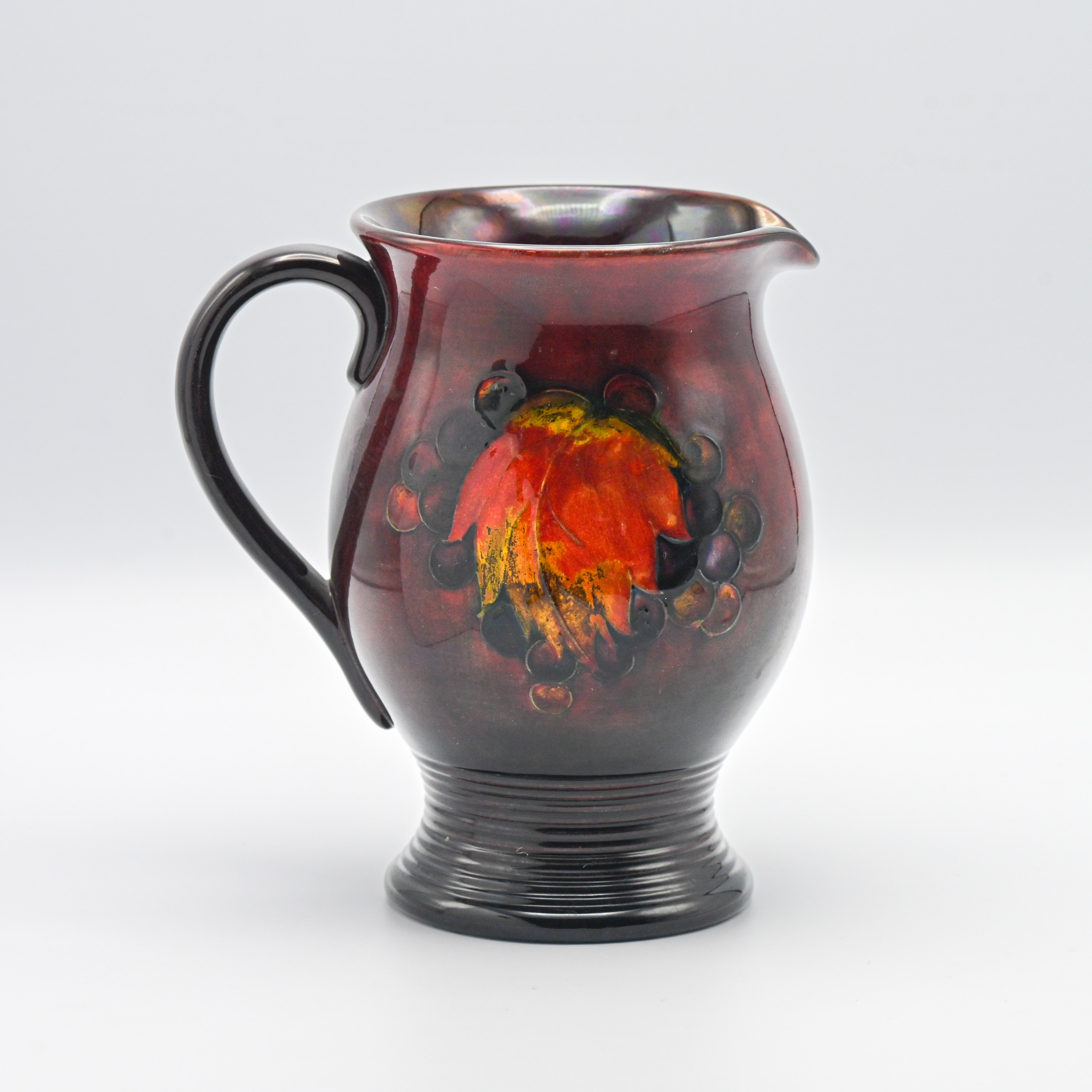 A William Moorcroft Flambe Leaf & Berries ribbed jug, 19cm height.