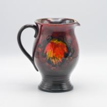 A William Moorcroft Flambe Leaf & Berries ribbed jug, 19cm height.