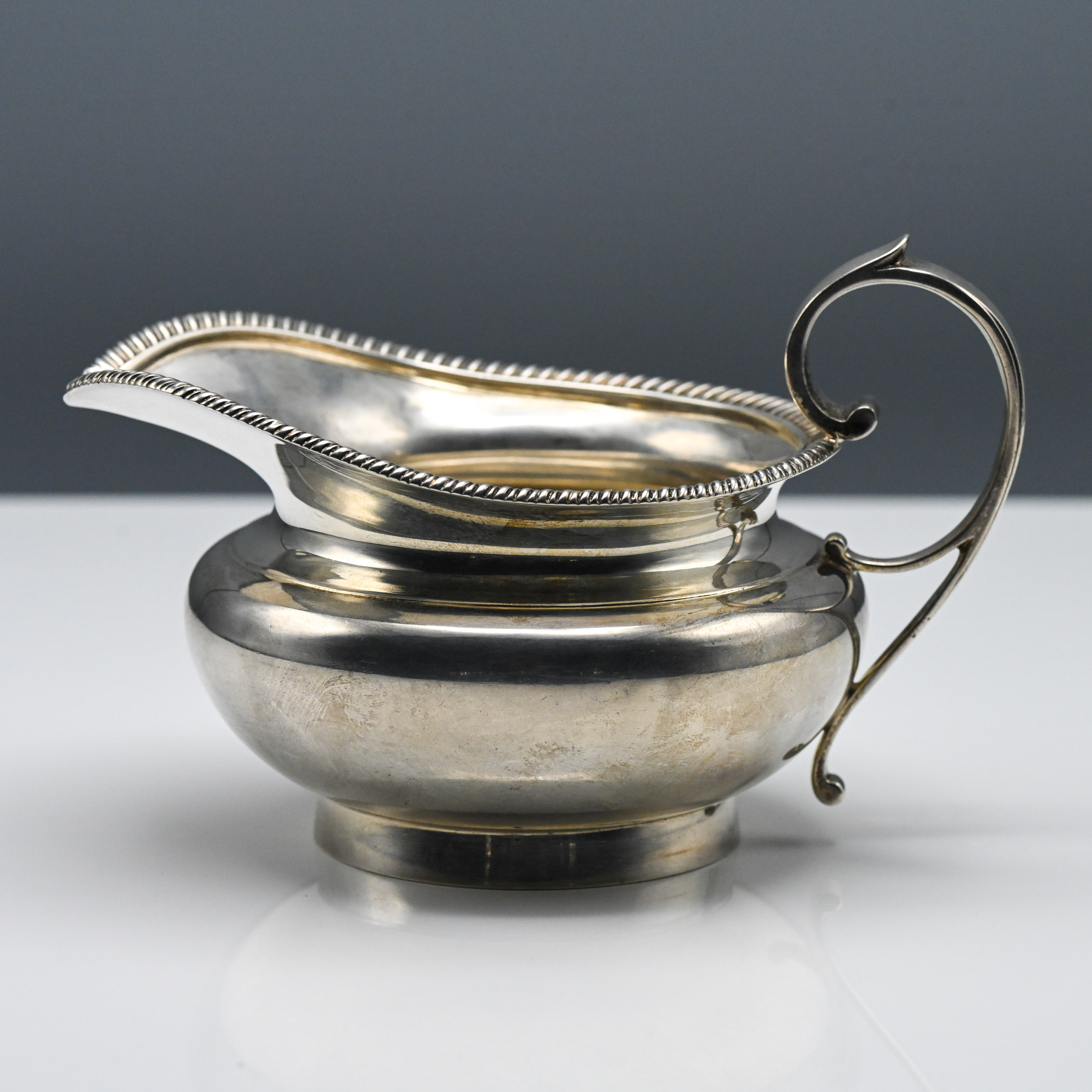 Edward VII silver cream jug, heavy gauge, bulbous design, scroll handle, London makers mark WM