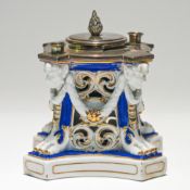 A 19th century silver mounted porcelain pen and ink stand decorated with face masks and paw feet,