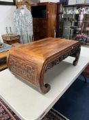 A Chinese hardwood coffee table, carved with the legs forming the scroll ends and the apron carved