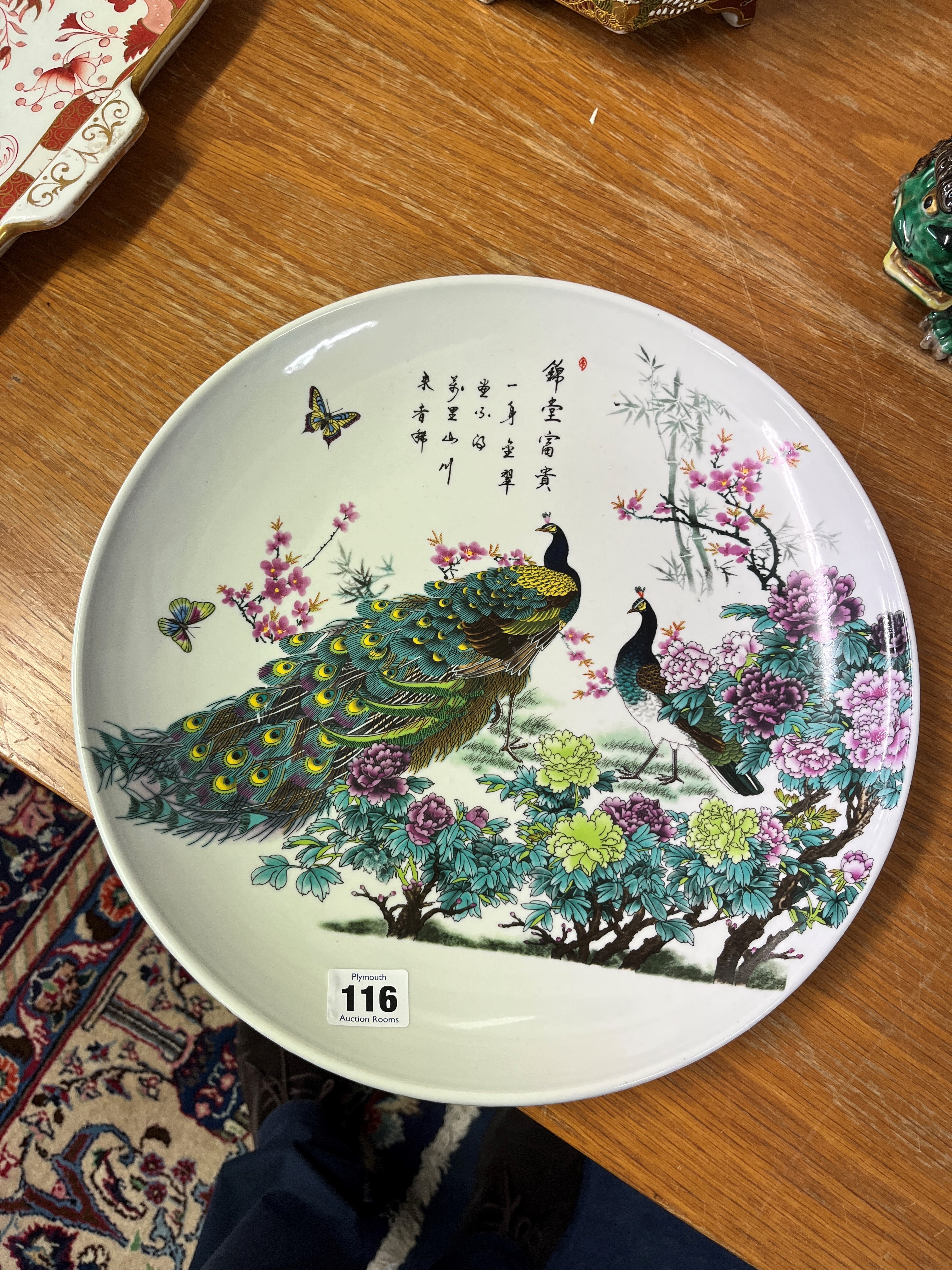 A 20th century Oriental wall plate decorated with peacocks and text, 34cm. - Image 2 of 2