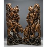 A pair of carved wood figures of Li Tieguai, each with the Daoist Immortal seated astride a mythical
