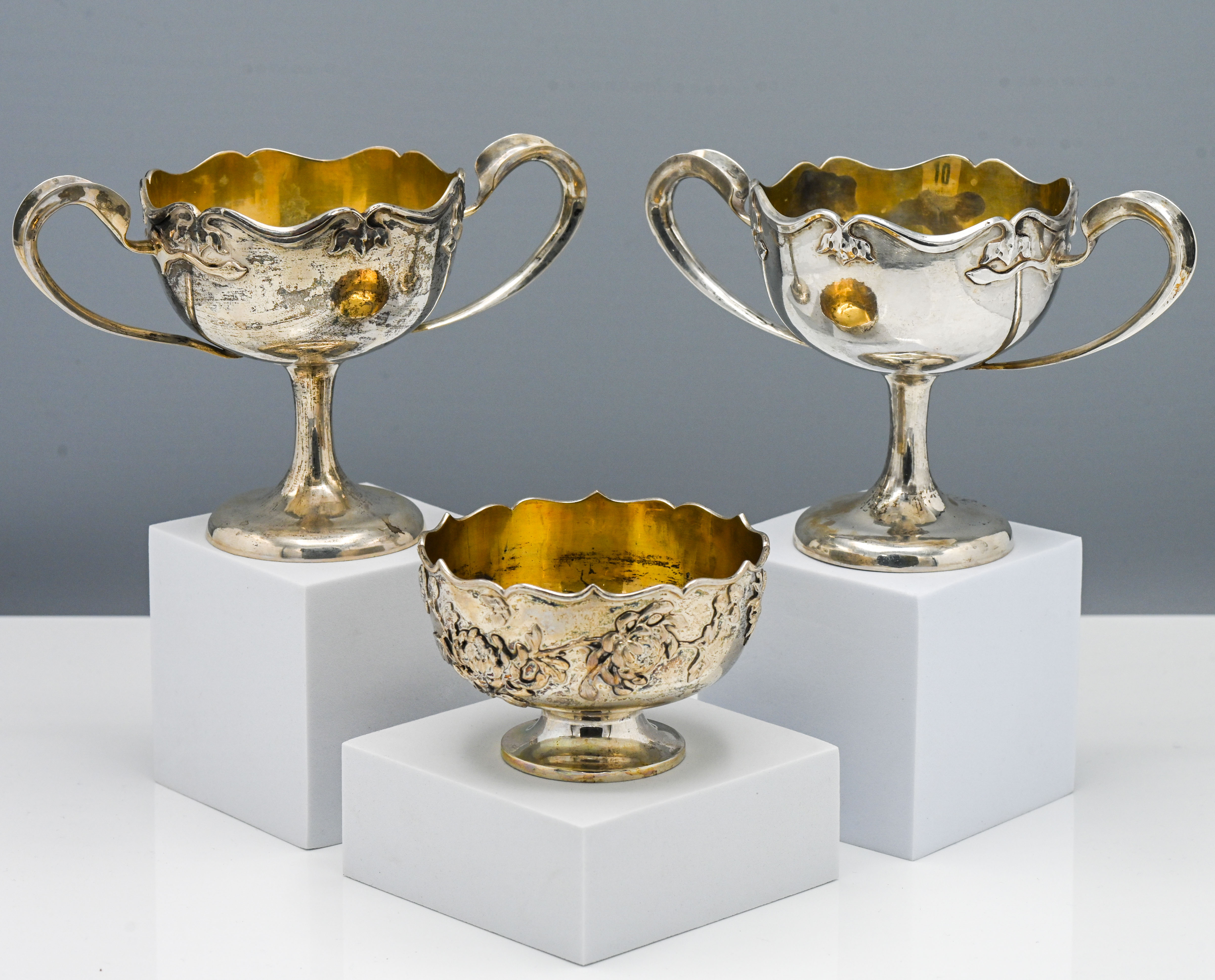 A pair of wine cups, each on a tall slender stem with a splayed foot, of rounded form with scalloped