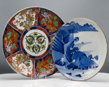 An Arita blue and white plate painted with a lake landscape, 31cm; together with an Imari Charger