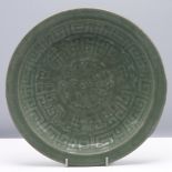 A celadon glazed saucer dish, Qing dynasty, 18th/19th century. Heavily potted and carved in low