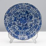 A barbed blue and white saucer dish, Kangxi (1662-1722) Decorated in the centre with blossoming