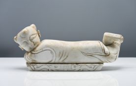 A marble pillow, 19th/20th century, carved in the form of a recumbent boy, his head turned to one