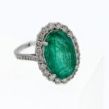 An 18ct white gold oval emerald and diamond ring, large oval cut centre emerald, diamonds to