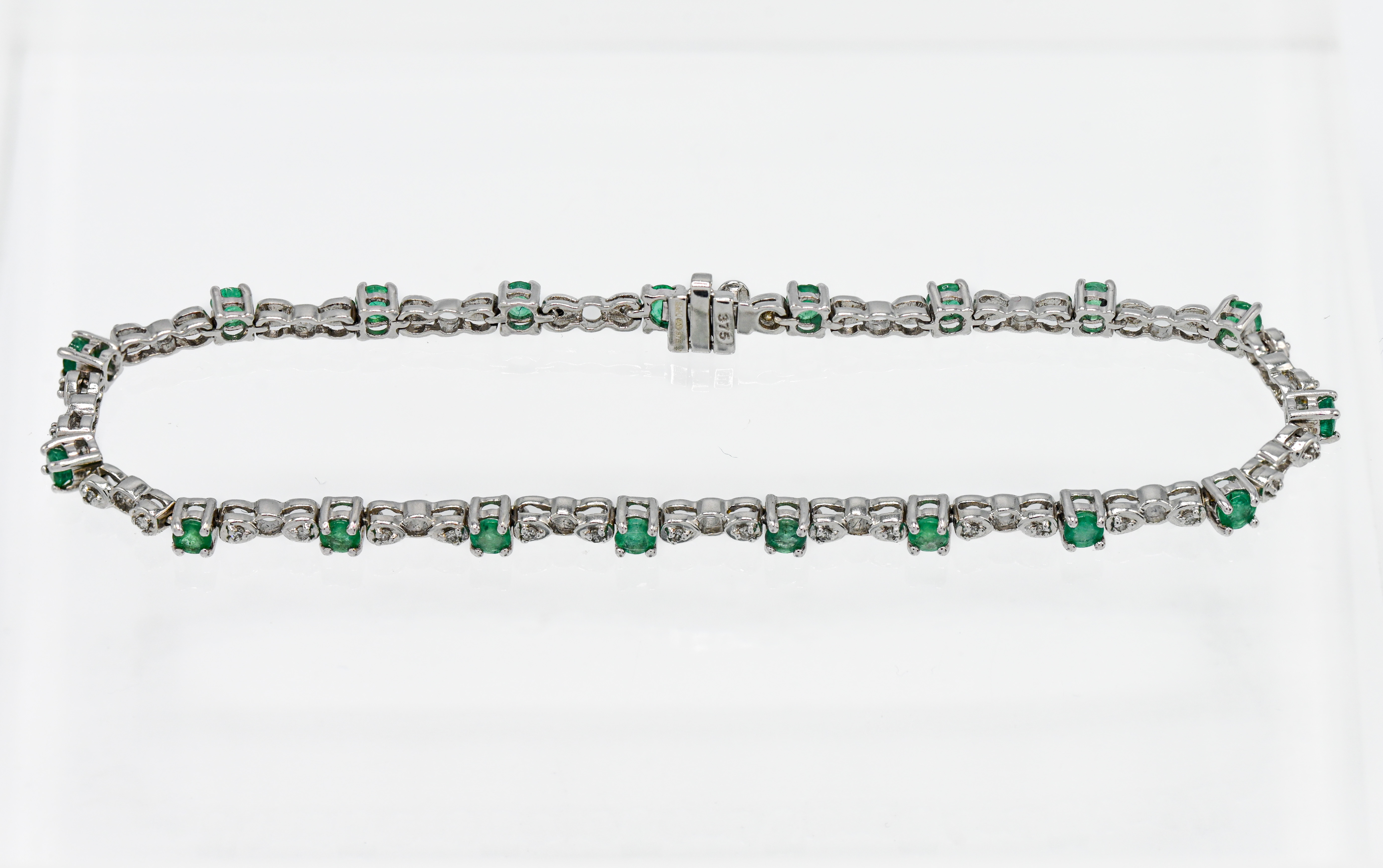 A 9ct white gold set emerald and diamond line bracelet, approx. 7.4g.