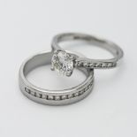 A platinum solitaire ring with central round brilliant diamond claw setting, with fourteen channel