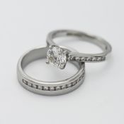 A platinum solitaire ring with central round brilliant diamond claw setting, with fourteen channel