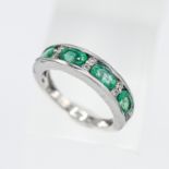 A 14ct white gold emerald and diamond 'Channel set' ring with four oval cut emeralds , size P.