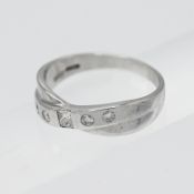 An 18ct white gold cross over diamond set half eternity ring, set with four modern brilliant and one