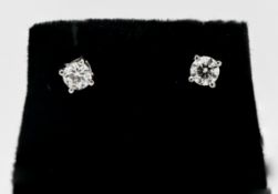 A pair of 18ct white gold single stone diamond studs, approx. 0.60 points in total.