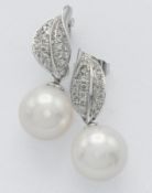 A pair of pearl and diamond earrings set in 9ct white gold of leaf design.