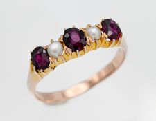 An antique rose gold ring set with garnet and pearls, five stones in total, size Q.