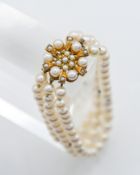 A triple row culture pearl bracelet, centre snap cluster format, 9ct yellow gold set, one pearl