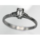 A platinum and diamond set single stone ring, set with an emerald cut diamond, size K.