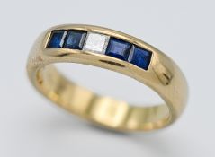 An 18ct yellow gold band channel set with princess cut diamond and four sapphires the band marked