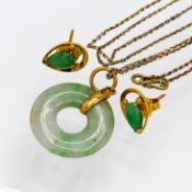 A twentieth century jade pendant set in a yellow metal mount on a fine chain, together with two jade