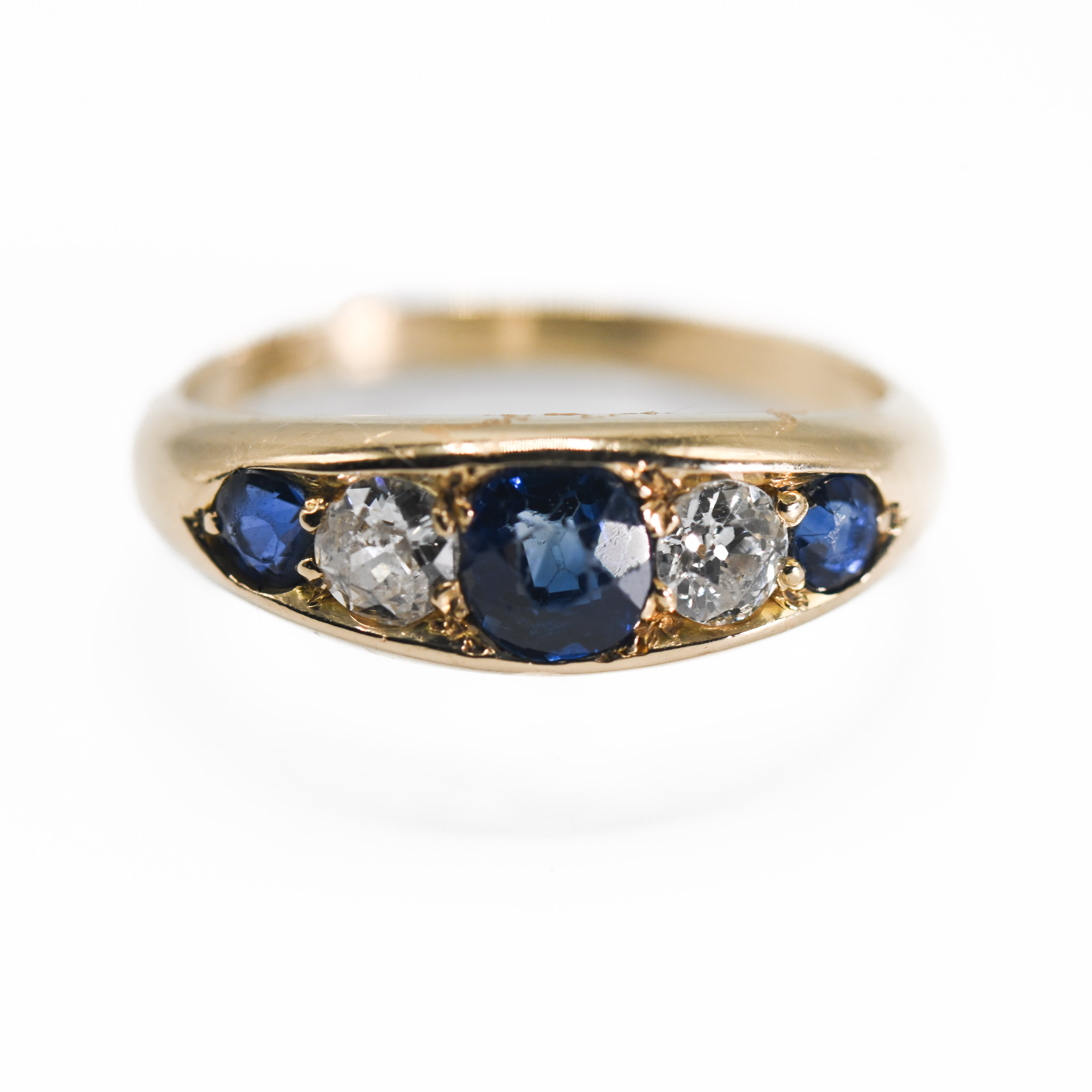 An antique 18ct yellow gold five stone ring set with three sapphires & two diamonds, the central