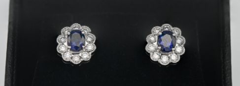 A pair of 18ct white gold diamond and sapphire flower design earrings.