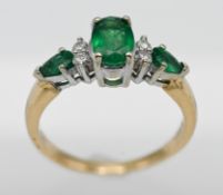 An 18ct yellow gold emerald and diamond ring, size N.